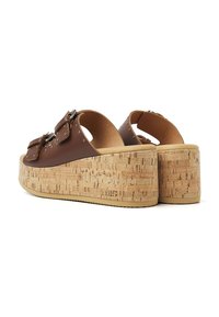 Sandales en cuir marron à plateforme avec double boucle, semelle intermédiaire en liège et détails texturés, présentant un dos ouvert et une semelle en caoutchouc.