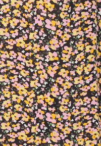 Musta kangas, jossa on kukkakuosi, joka sisältää vaaleanpunaisia, keltaisia ja valkoisia kukkia sekä vihreitä lehtiä ripoteltuna ympäriinsä.