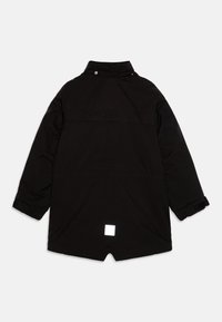 Parka nera con colletto alto, chiusura a bottoni, polsini elasticizzati e una toppa quadrata riflettente sulla parte posteriore. Texture liscia.