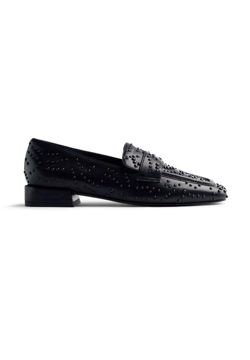 Mocassins en cuir noir avec un design texturé et des clous en relief. Talon bas et bout arrondi. Surface lisse avec des accents détaillés.