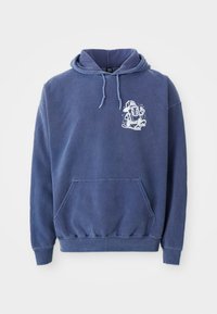 Hoodie in Marineblau mit einer Fronttasche, Kapuze mit Kordelzügen und einem weißen Cartoon-Graphic auf der Brust. Hergestellt aus weichem, strukturiertem Stoff.