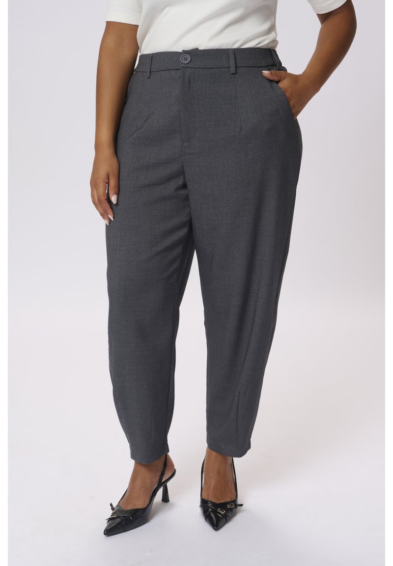 Pantaloni grigi a vita alta con taglio dritto, caratterizzati da una texture sottile e due tasche laterali, abbinati a décolleté nere con punta appuntita.