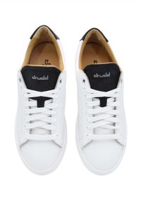 White leather sneakers with black suede accents at the tongue, flat laces, and a rubber sole. Interior lined in tan fabric.