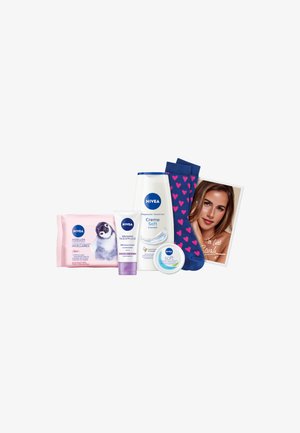 NIVEA products including pink micellar wipes, a white body wash, a cream, and blue socks with pink hearts, plus a photograph with handwritten note.
