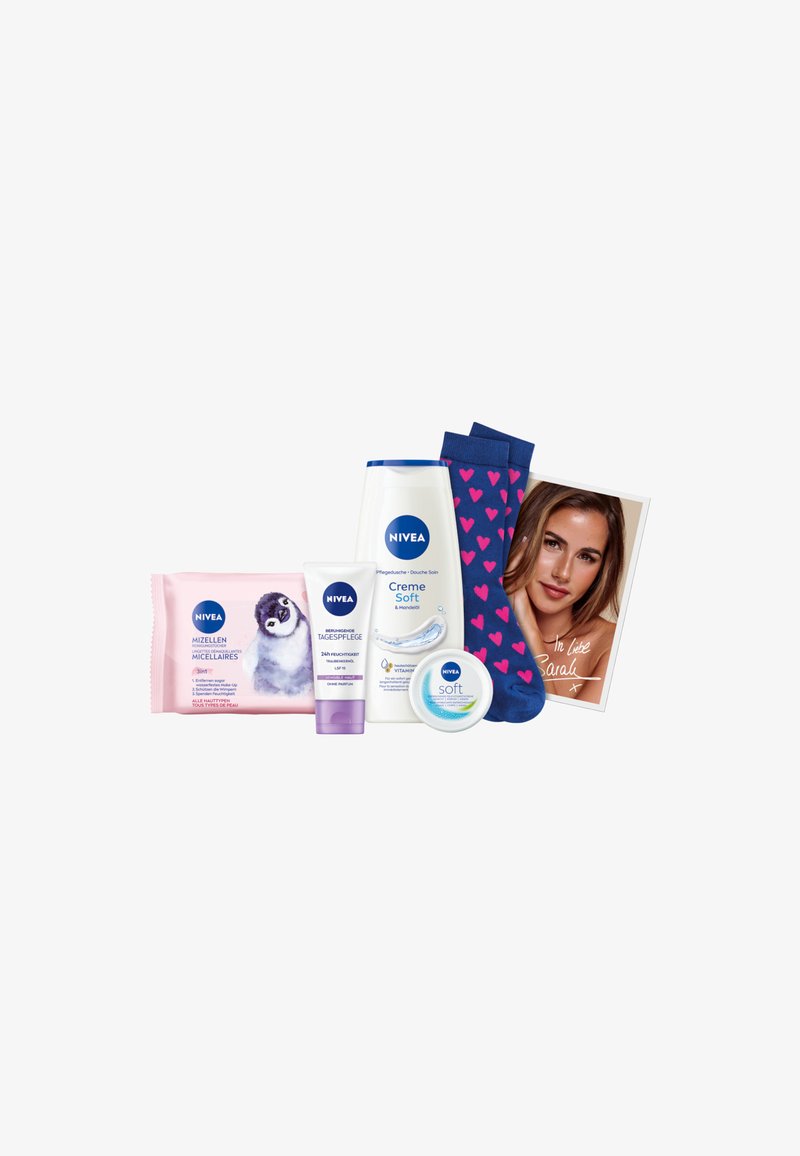 NIVEA products including pink micellar wipes, a white body wash, a cream, and blue socks with pink hearts, plus a photograph with handwritten note.