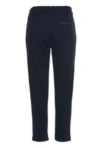 Marineblaue Hose mit elastischem Bund, zwei Gesäßtaschen und einem Logodetail auf der Rückseite. Hergestellt aus einem weichen, strukturierten Stoff.