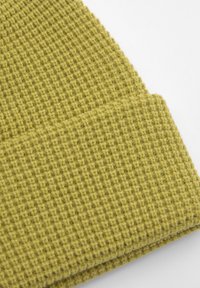 Beanie de tricot waffle, verde măsliniu, cu o textură moale și tiv pliat, conceput pentru căldură și confort.