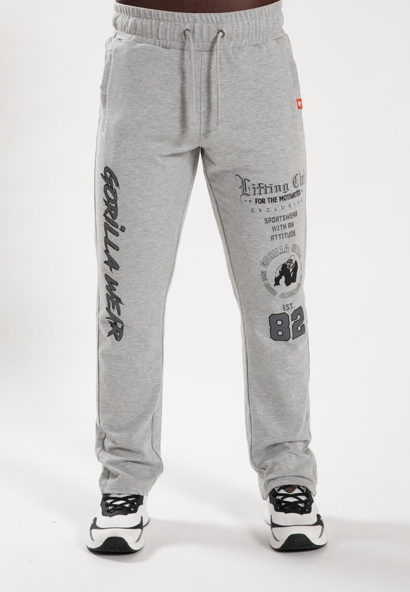 Grijze sweatpants van een katoenmix stof. Voorzien van bedrukte graphics op het linker been en het zakgebied, met een elastische tailleband en een koord.