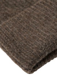 Gros plan sur une écharpe en laine tricotée marron repliée, avec une texture côtelée et des fibres douces et duveteuses.