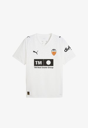 Biała koszulka piłkarska z krótkim rękawem i dekoltem w kształcie V, z logo Valencia CF, czarnym tekstem sponsora i subtelną teksturą geometryczną.