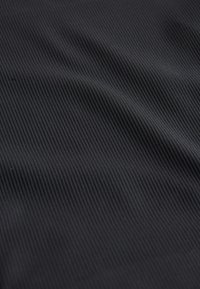 Czarna tkanina o delikatnej, pionowej fakturze prążków, miękki materiał, gładka powierzchnia i lekki połysk. Brak wyraźnych wzorów lub akcentów.