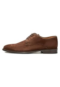 Brązowe zamszowe buty do garnituru mają zaokrąglony czubek, minimalne przeszycia i gładką podeszwę. Sznurowana konstrukcja o eleganckim, nowoczesnym wyglądzie.