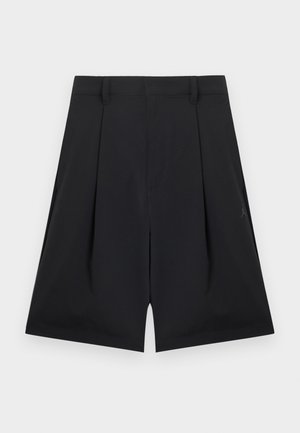 Sorte knælange shorts med bæltestropper, forreste folder og et diskret logo på højre side mod en ensfarvet baggrund.