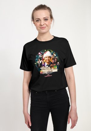 Czarny bawełniany t-shirt z kolorową grafiką mężczyzny w czapce Świętego Mikołaja, otoczonego świątecznymi elementami i postaciami z filmu.