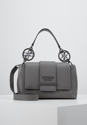 Sac à main gris Guess avec poignée supérieure et bandoulière longue amovible, avec des breloques métalliques rondes du logo et un rabat avant avec embossage de la marque.