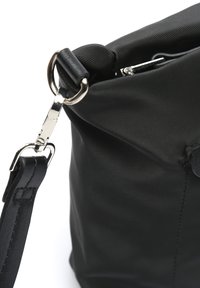 Crna najlonska torbica sa mekim teksturom, koja se ističe metalnim kopčom i podesivim kožnim remenom.
