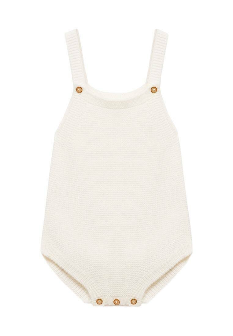 Knit romperin vaalean kermanvärinen, jossa on säädettävät olkaimet ja puunappikoristeet. Sisältää pehmeän tekstuurin ja napinetteen alaosassa.