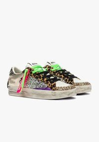 Sneakers bassi con stampa leopardata, pannelli glitterati, lacci verde neon e neri, accenti viola e un'etichetta rosa che pende da una scarpa.