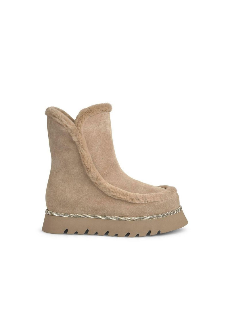 Bottes en daim tan avec un bout rond, doublure en fausse fourrure et une semelle épaisse à zigzag. Une bande décorative court le long de la base de la tige.