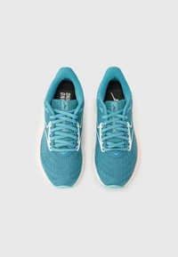 Τιρκουάζ αθλητικά παπούτσια με επάνω μέρος από δίχτυ, λευκές λεπτομέρειες και μπλε κορδόνια. Η σόλα είναι λευκή με ροζ λεπτομέρεια. Σημαντικό λογότυπο στη γλώσσα.