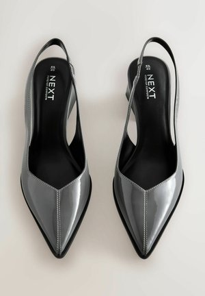 Szare, lakierowane skórzane czółenka typu slingback z ostro zakończonym noskiem i niskim słupkowym obcasem. Posiadają detal w postaci przeszycia oraz wyściełaną wkładkę.