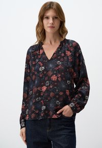 Blusa floreale in tessuto blu scuro, caratterizzata da un colletto a V, maniche lunghe e arricciature sullo scollo. Decorata con fiori multicolori e dettagli.
