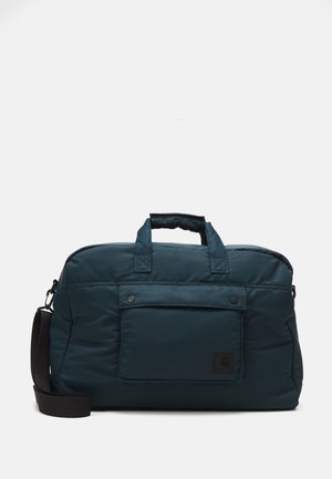 Bolsa de lona de poliéster en color verde azulado con dos asas superiores, una correa de hombro desmontable, un bolsillo frontal y un parche con el logotipo. Textura suave y acolchada.