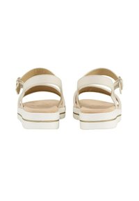 Sandalias blancas con una parte superior texturizada, correa de tobillo ajustable y una plantilla contorneada. La suela presenta una sutil franja de acento beige.
