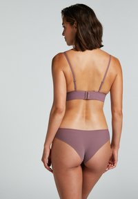 Maudy bikini set met een minimalistisch ontwerp, verstelbare bandjes en een haaksluiting op de rug. Gladde textuur zonder patronen.