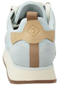 Light blue sneaker with suede and mesh materials. Features a brown textured heel tab and cream-colored sole. Prominent logo on tab.