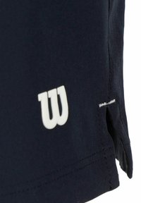 Pantalones cortos deportivos azul marino con un logotipo blanco "W", compuestos de una tela que absorbe la humedad, con una ventilación lateral y costuras limpias.