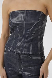 Top senza spalline in denim blu scuro con cuciture bianche a contrasto. Presenta un design aderente e una texture liscia.