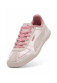 Sneaker Puma rosa chiaro con tomaia testurizzata, lacci e logo. Esibito su uno sfondo bianco, inclinato per mostrare i dettagli.