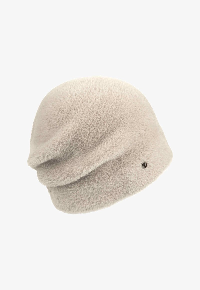 Mjuk, ljus beige fluffig mössa med lös passform och en liten svart knappdetalj på sidan.