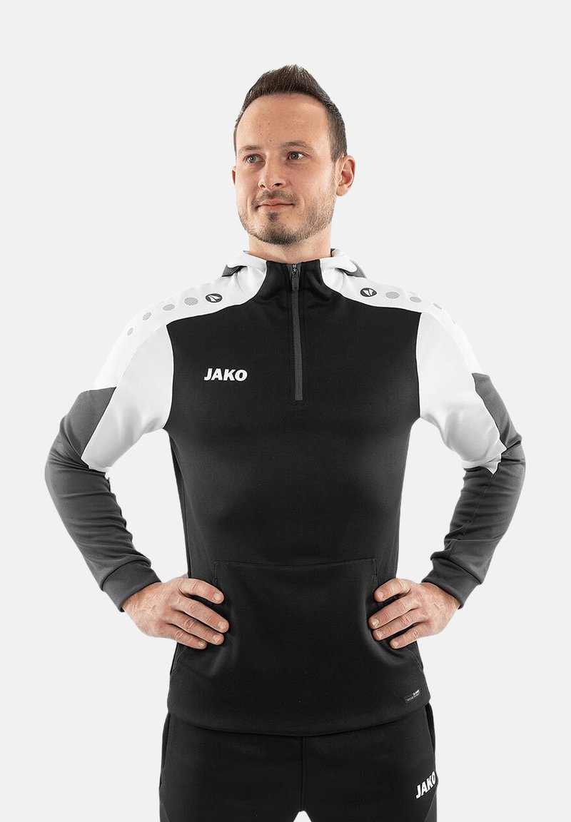 Haut de sport noir et blanc à demi-zip avec poche kangourou, logo brodé et design à pois sur les épaules. Fabriqué en tissu lisse.