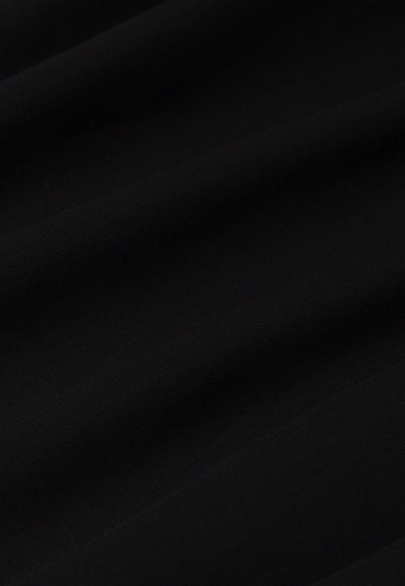 Dünner schwarzer Stoff mit glatter Textur, der subtile Falten und eine einheitliche Farbe über die gesamte Oberfläche aufweist. Geeignet für verschiedene Anwendungen.