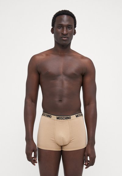 Beige boxer alsónadrág fekete "Moschino" derékkal; testhez simuló kialakítás sima textúrával és kontúros zsebbel a kényelem érdekében.