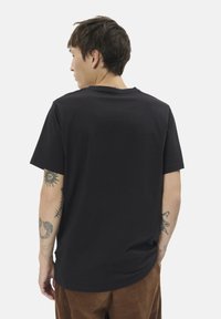 Čierne tričko s krátkym rukávom vyrobené z mäkkej látky, s klasickým kulatým výstrihom a voľným strihom, zobrazené zozadu.