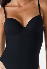 Costume da bagno intero nero con spalline sottili regolabili, coppe modellate e un materiale liscio e elasticizzato. Progettato con una silhouette elegante e aderente.