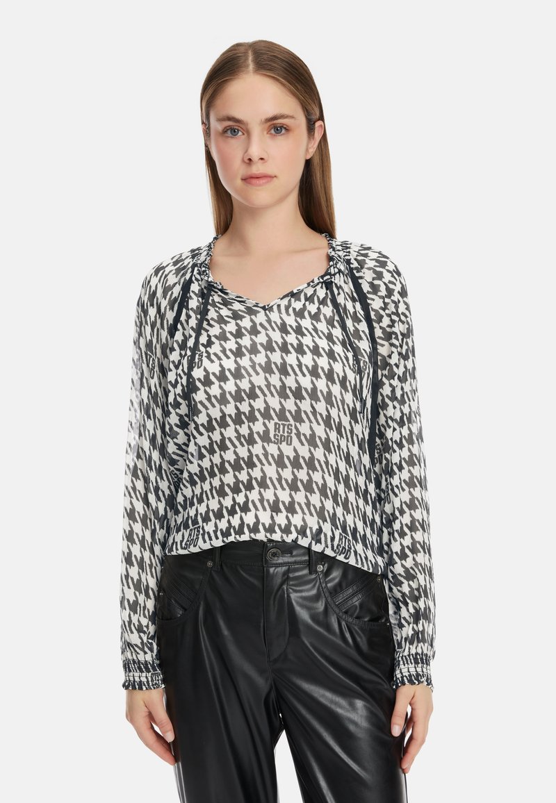 Schwarz-weißes Hahnentritt-Bluse mit V-Ausschnitt, Zugbandschmuck am Ausschnitt und langen Ärmeln. Der Print von 2023 fügt Textdetails hinzu.