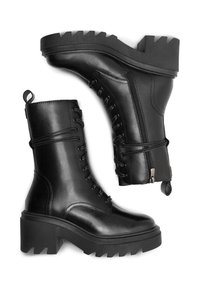 Melnas ādas potītes zābaki ar masīvu platformas zoli, auklām priekšā un sānu rāvējslēdzēju. Iespējas ietver strukturētu papēdi un cilpu vieglai uzvilkšanai.