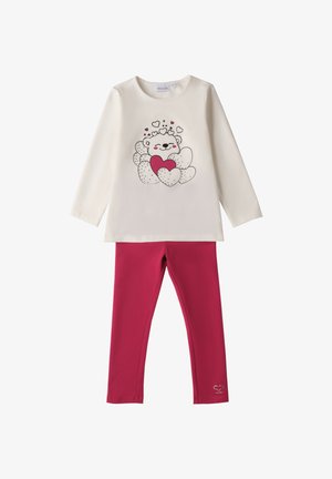 Camisa blanca de manga larga con un gráfico de un oso de peluche abrazando corazones, combinada con unas mallas de color rosa oscuro sólido que tienen un pequeño detalle de corazón cerca del tobillo.