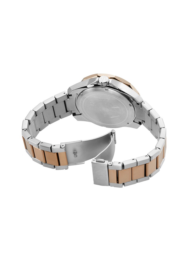 Montre métallique avec un bracelet en acier inoxydable argenté et des accents en or rose. Dispose d'un boîtier rond, d'une surface polie et d'une fermeture à clip.
