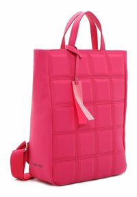 Bolso tote rosa con diseño acolchado, hecho de material sintético. Presenta dos asas cortas y una correa desmontable. Etiqueta adjunta.