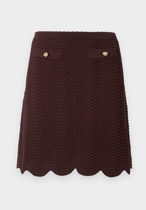 Jupe en maille marron foncé avec un motif texturé ondulé, un ourlet festonné et deux petites poches avant avec des boutons dorés.