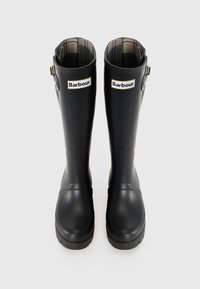 Pair of black Barbour knee-high rubber rain boots with plaid lining and adjustable side buckles, shown upright on a plain background.