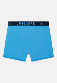 Blå mesh boxershorts med marineblå elastisk midjebånd som har hvite "JORDAN" bokstaver og et Jumpman-logo på forsiden.