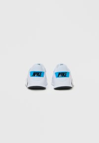 Ein Paar weiße Nike-Laufschuhe, die von hinten gezeigt werden, mit blauen Fersenlaschen und schwarzem "NIKE"-Text auf einem schlichten weißen Hintergrund.