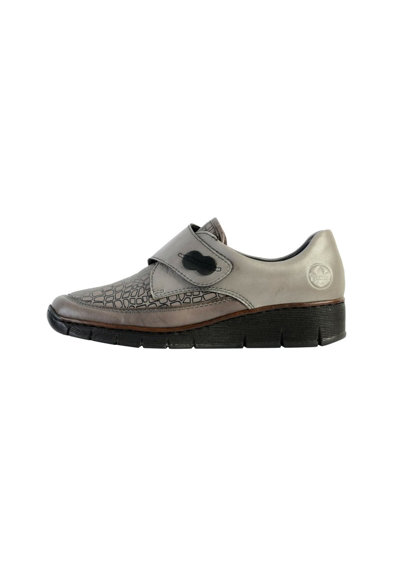 Chaussure en cuir gris avec un motif crocodile noir texturé, bande velcro et une semelle en caoutchouc noir robuste. Présente un design de bout arrondi.