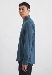 Teal gemêleerde button-up shirt met een kraag, lange mouwen en knoopaccenten. De stof heeft een gestructureerd ontwerp.